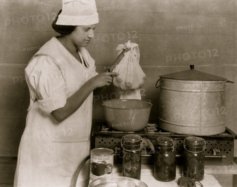 One of the Cabel County Demonstration Team demonstrating the process of blanching tomatoes to visitors at the 4 H Club Fair.  1921