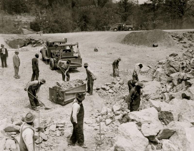 Prisoners breaking up rocks at a prison camp or road construction site 1941