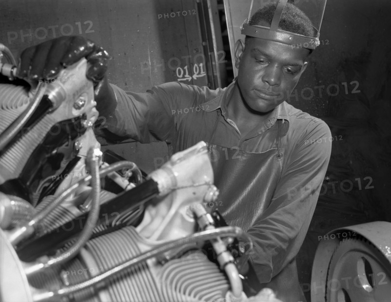 Production. Aircraft engines. A young Black worker stands ready to wash or "degrease" this airplane motor prior to its shipment. He's an employee of a large Midwest airplane plant. Melrose Park, Buick plant 1943