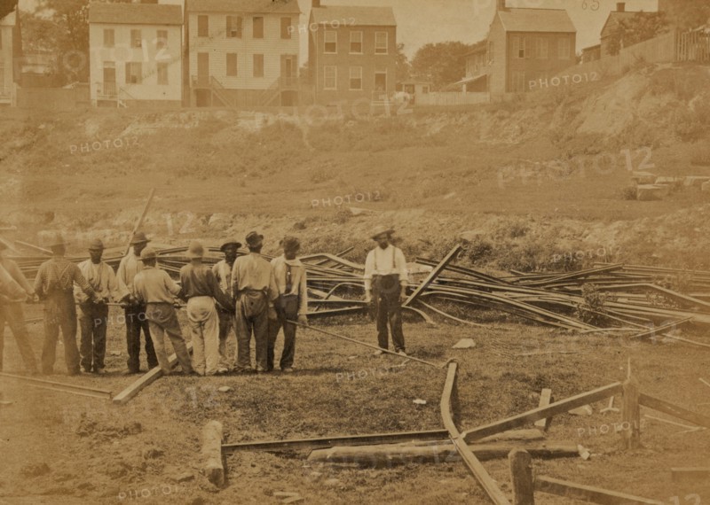 Railroad construction workers straightening track 1863