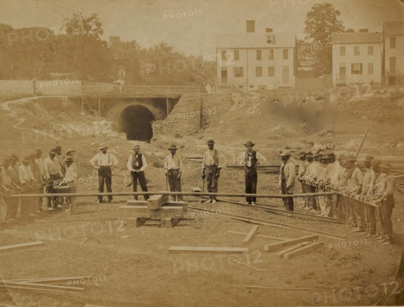 Railroad construction workers straightening track 1863