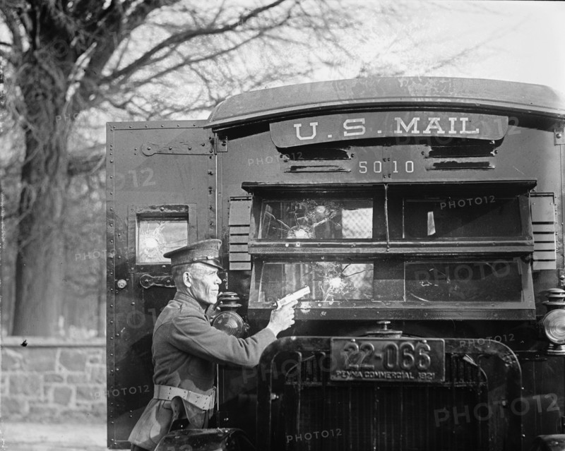 Uniformed Postal Official tests Regulation Army 44 Colt and its effect on bullet proof glass used in the new armored postal trucks 1921