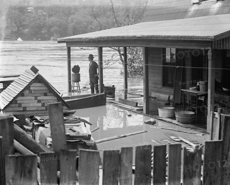 Rising River Floodwaters approach a man who stands on his front porch 1924
