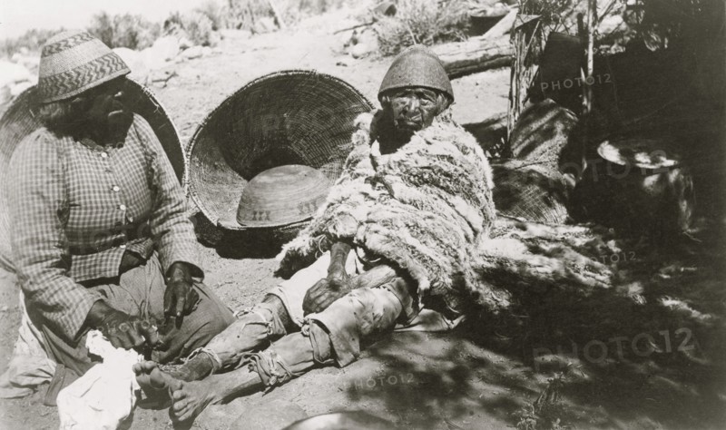 Two old Paiute Indian women with baskets and woven hats, one identified as Teha 1902