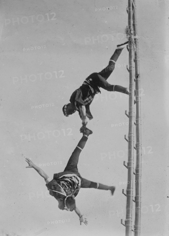 Two Tokyo Firefighters display acrobatic skill on very high bamboo ladders