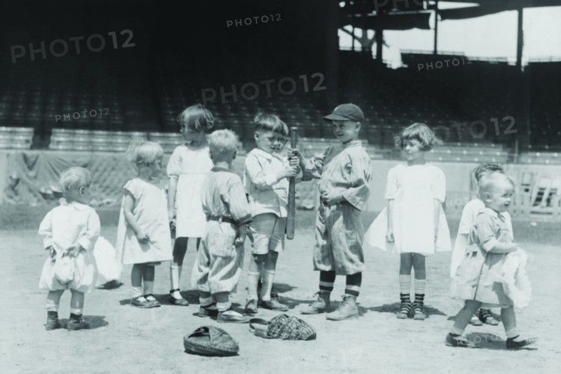 Toddlers on Baseball Field grasp a bat to select team members