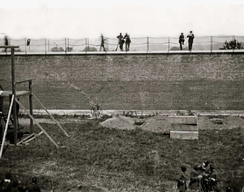 Washington, D.C. Coffins and open graves ready for the conspirators' bodies at right of scaffold 1865