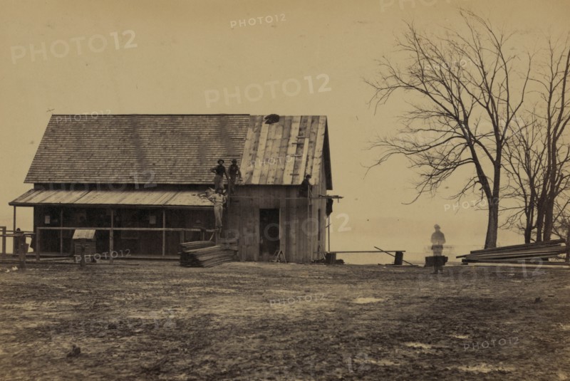 Workers constructing a wood building 1863