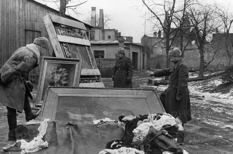 Red army soldiers with recovered paintings stolen from the peterhof palace (petrodvorets) and pushkin palace (tsarskoye selo) by the germans, abandoned in east prussia during the nazi retreat, world war 2, 1945.