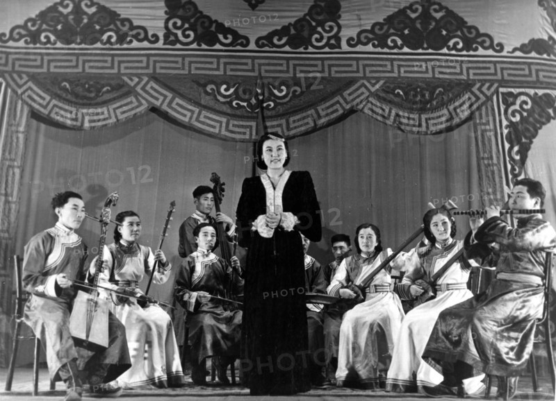 Mongolian singer tsogzolma performs a traditional mongolian song accompanied by the mongolian folk instruments ensemble, mongolia, january 1950.