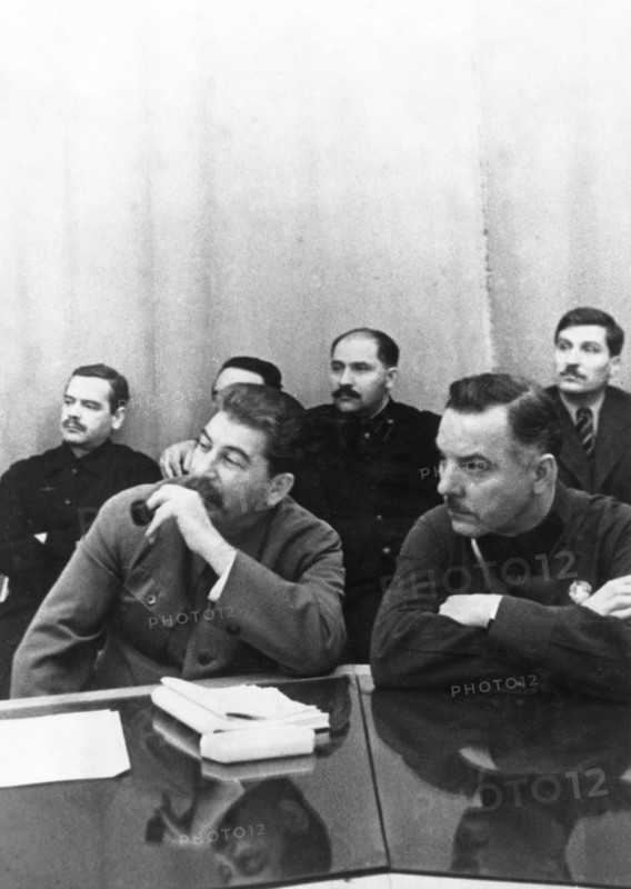 Joseph stalin (front, left) sits with k,e, voroshilov at a conference of best combine workers and soviet government, left to right, back: a,a, andreyev, l,m, kaganovich, v,j, chubar, ussr, 1930s.