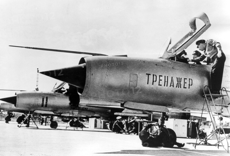 September 1966: a north vietnamese student pilot in a non-flying mig-21 fighter jet trainer, with him is his soviet flight instructor, lettering on fusilage: 'trainer'.
