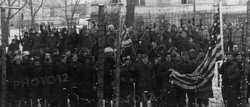 The red army freed them, americans and british prisoners of war in the yard of a german prison camp, near poznan,  they wanted to have their pictures taken behind the barbed wire fence, which separated them from the rest of the world for several years.