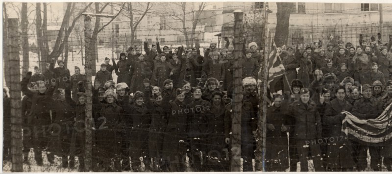The red army freed them, americans and british prisoners of war in the yard of a german prison camp, near poznan,  they wanted to have their pictures taken behind the barbed wire fence, which separated them from the rest of the world for several years.