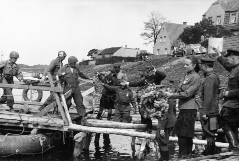 Soviet red army troops meeting the troops of the 1st american army as they cross the elba river near torgau, germany on april 25, 1945.