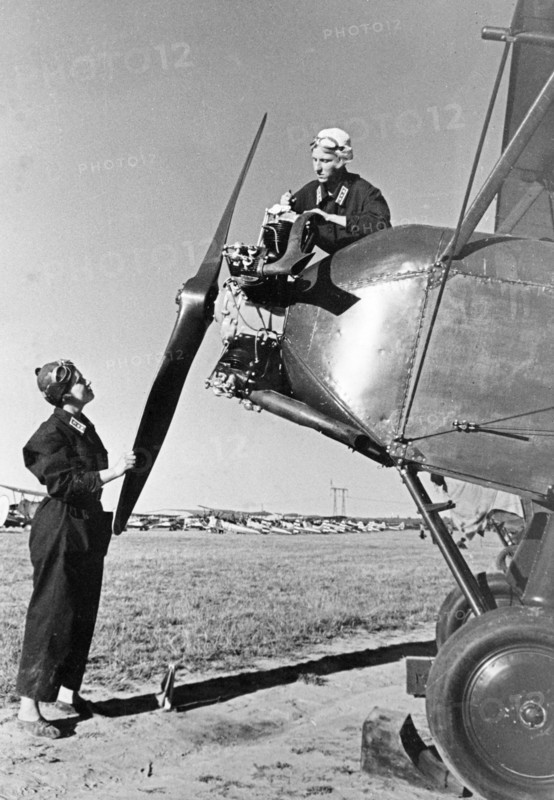 Members of an all woman's squadron prepare for the forthcoming all-union aviation day air show, august 18, 1939, the commander of the women's squadron, pilot/instructor of the kiev district (moscow) t, dolbilova (left) and technician/navigator of the same airclub, e, budanova, are making adjustments to the engine of their plane, a polikarpov po-2 (u-2).