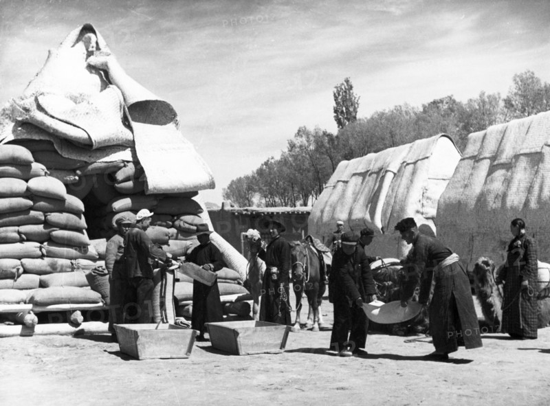 Mongolian herdsmen buying food at a state grain supply center in payinhota, the seat of the mongolian autonomous government in ningsia province, china, august 1954.