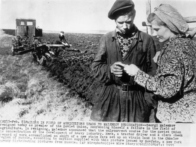A tractor driver and clerk checking the record of work accomplished on a shift of a new state farm set up on virgin land in the chkalov region of russia, 1955.