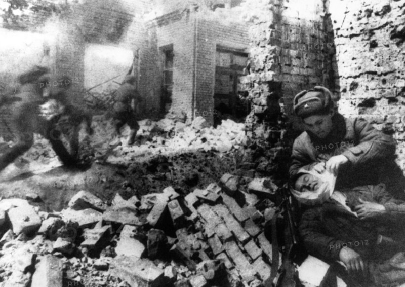 Nurse bandaging a wounded soldier during street fighting in stalingrad, december 1942.
