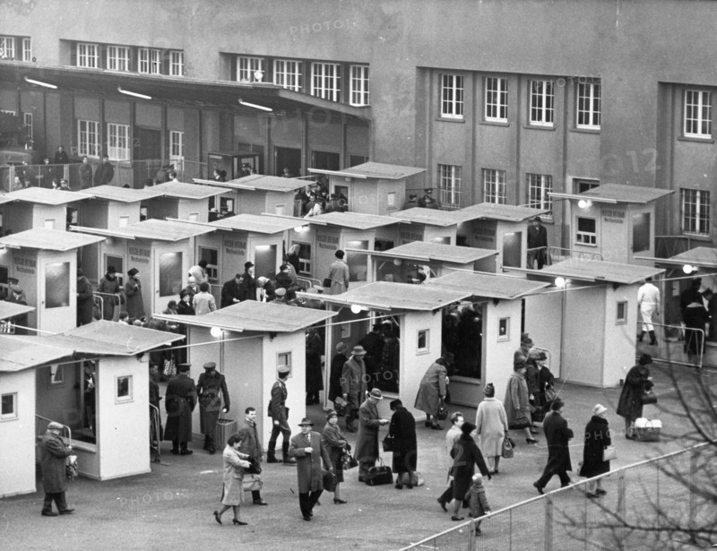 West berliners crossing over to visit relatives in east berlin in accordance with a recently signed treaty allowing such visits, october 1964, pictured are the customs booths at the friedrich strasse checkpoint set up specifically to handle the traffic.
