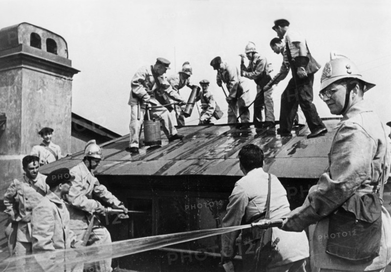 world war ll, composer dmitri shostakovich (right), member of the volunteer fire fighting squad of the leningrad conservatory, during a drill in which he and the other teachers learn to handle incendiary bombs.