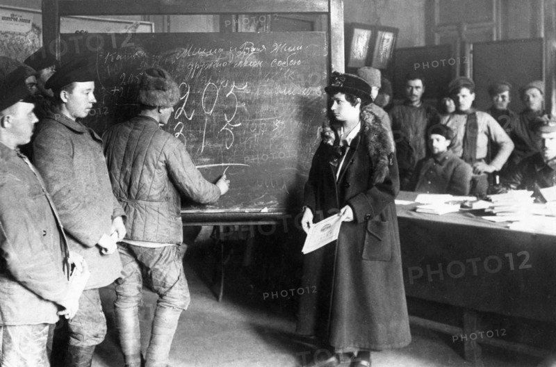 An early post-revolution classroom where adults are being taught to read, write, and do arithmatic, 1920s.