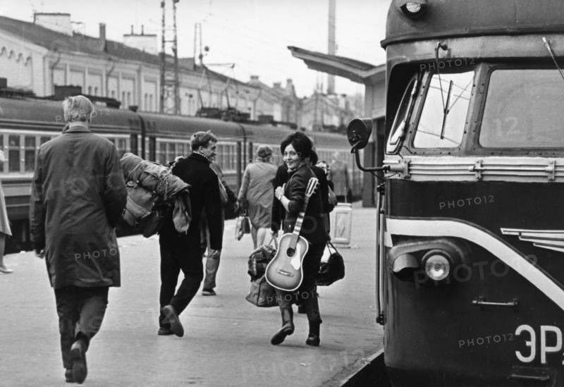 A young russian couple at a moscow train station, leaving the city with rucksack and guitar, vacation, ussr, 1970.
