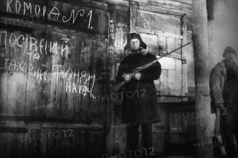 An armed man guards the storage of crop and emergency supply grain for the year 1934 in this documentary photograph displayed at an exhibition in kiev, dedicated to holodomor, the great ukrainian famine of early 1930s.