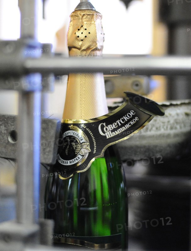 Moscow, russia, november 29, 2010, a label being applied to a bottle of sovetskoye shampanskoye on a bottling line at kornet, a moscow-based champagne winery.