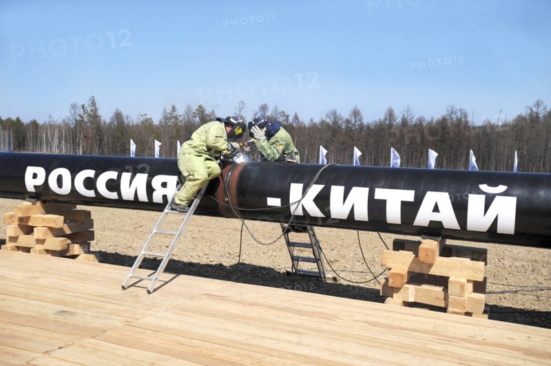 Amur region, russia, april 27, 2009, workers welding the first segment of a branch pipeline which will run into china from the eastern siberia – pacific ocean (espo) oil pipeline, the slogan on the pipeline reads: russia - china.