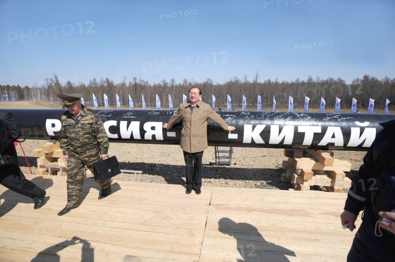 Amur region, russia, april 27, 2009, chinese official posing near a branch pipeline which will run into china from the eastern siberia – pacific ocean (espo) oil pipeline, the slogan on the pipeline reads: russia - china.