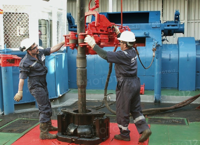 Oil drillers seen at work at lukoil's astra offshore oil rig which conducts surveying drilling of an oil-field on the caspian sea shelf, astrakhan region, russia, september 2 2003.