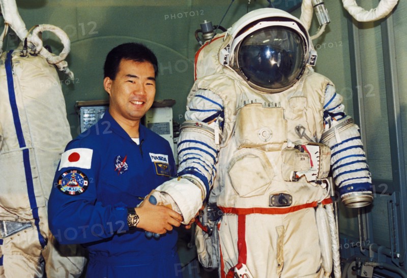 Japanese astronaut soiti noguti posing with a russian sokol spacesuit, 1998.