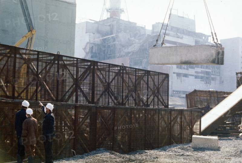 Construction crews building a containment wall around the damaged unit 4 reactor, chernobyl aps, ukraine, ussr, august 1986.