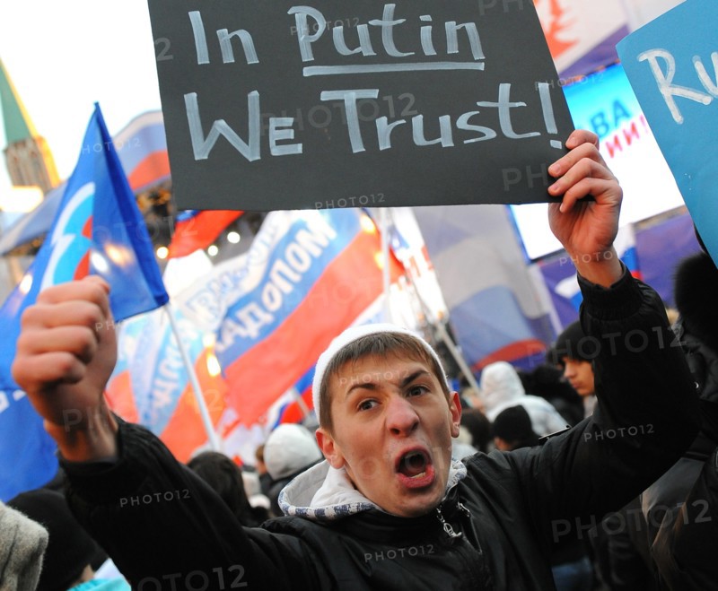 Moscow, russia, december 12, 2011, a young demonstrator holds up a sign reading in putin we trust during a rally staged by pro-kremlin youth groups in central moscow, the event took place two days after a mass protest against alleged vote rigging in the 4 december parliamentary election.