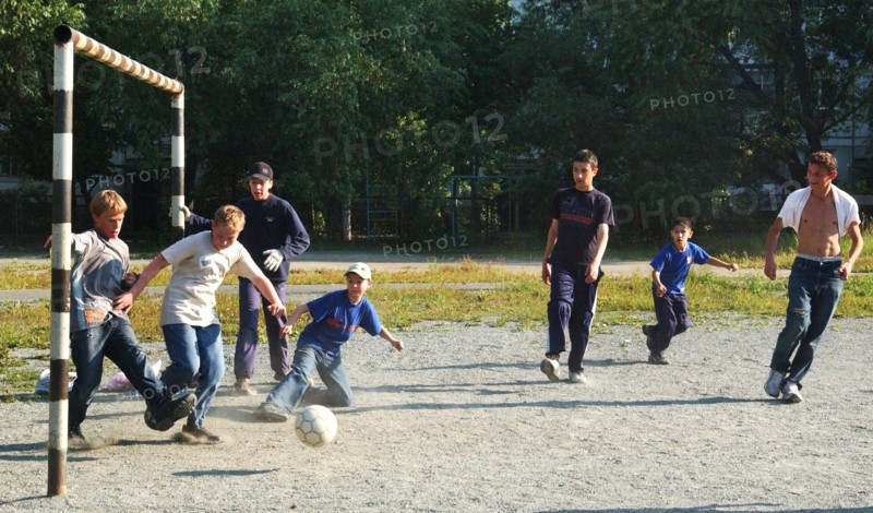 Teenagers play football in a chelyabinsk yard, russia, august 2006.