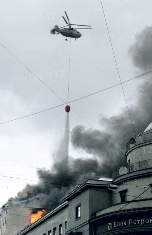 A firefighting helicopter drops water on a building engulfed by flames in petrovka street, central moscow, russia, august 26, 2006.