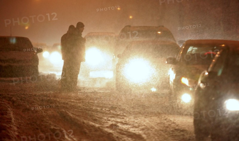 Moscow, russia, february 13, 2007, cars driving along a street with their headlights on in snowy blizzard.