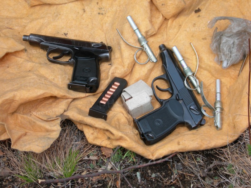 Two izh baikal guns with gun silencers, gun cartridges, grenade fuses found in a weapons and ammunition cache uncovered in chita region, may 25, 2007.