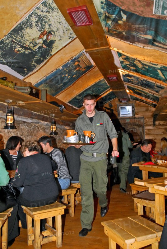 Waiter serving drinks at kryivka, a new cafe with the decor of a upa (ukrainian insurgent army) bunker, in the city of lvov (lviv), western ukraine, october 2007.