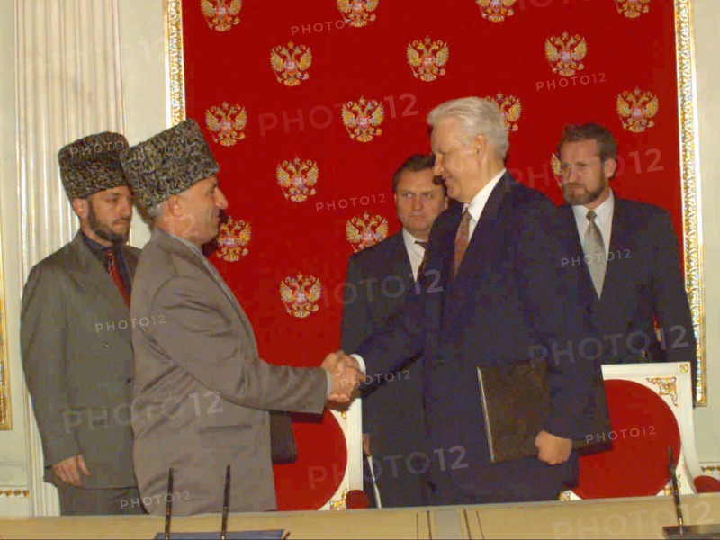 A treaty on peace and principles of mutual relations between the russian federation and the chechen republic of ichkeria has been signed today, on may 12, 1997 by president boris yeltsin and chechen leader aslan maskhadov, the picture shows the presidents shaking hands after the signing, in the background is russian security secretary ivan rybkin /centre/ , chechen vice-premier movladi udugov /left/ and chechen president's aide for national security akhmed zakayev /right.