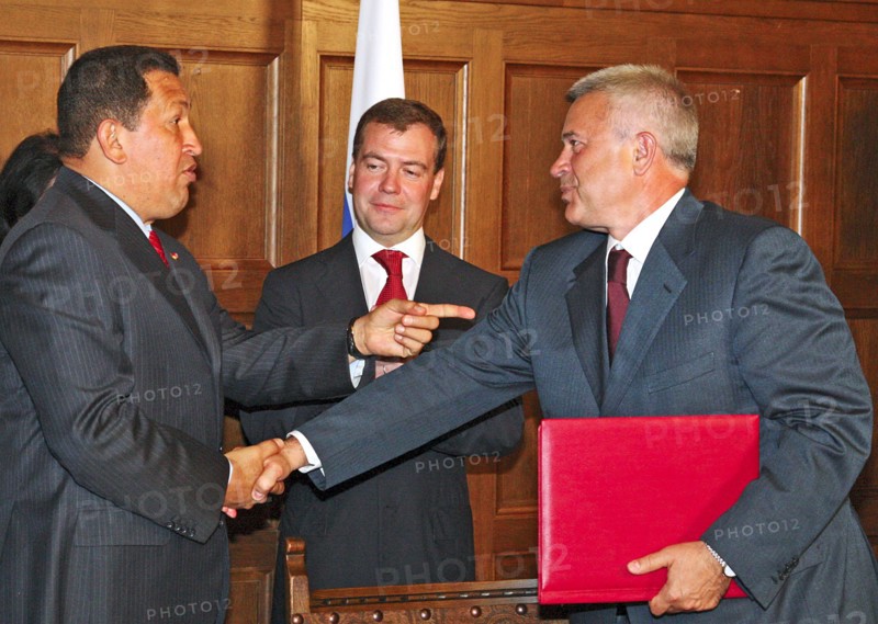 Moscow region, russia, july 22, russian president dmitry medvedev (c) looks on as venezuela's president hugo chavez (l) shakes hands with vagit alekperov, president of lukoil, russian oil company, at an agreement signing ceremony between russia and venezuela at the meindorf residence.