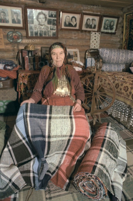 Peasant raisa orekhova of the udmurt village of zavyalovo with mats she wove, udmurtia, siberia, russia, 2/93.