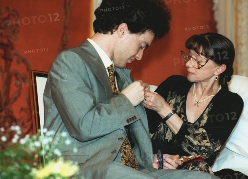 Moscow, russia 6/26/97: famous ballet dancer yekaterina maximova /right/ attaches a badge of russian independent 'triumph' prize to prominent russian pianist yevgeny kisin who lives now in the united states, the ceremony was held at bethoven hall of the bolshoi theatre, the prize set up in 1992 mark outstanding achievements in literature and arts, sponsor of this prize is js'logovaz'.