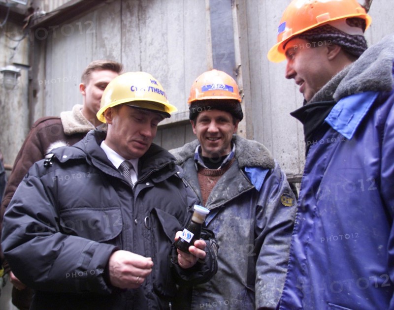 Surgut,russia, march 3 2000, russia`s acting president vladimir putin (l) looking at the souvenir