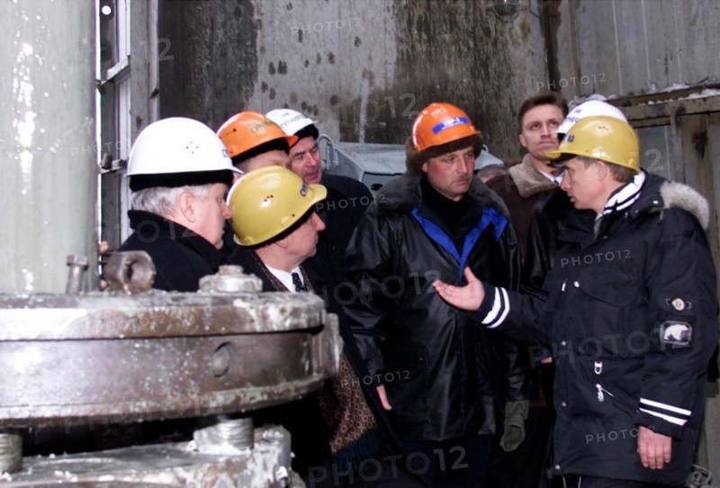 Surgut,russia, march 3 2000, acting president vladimir putin (right) wearing a helmet talks to oil workers during his visit to a drilling station near the western siberian city of surgut