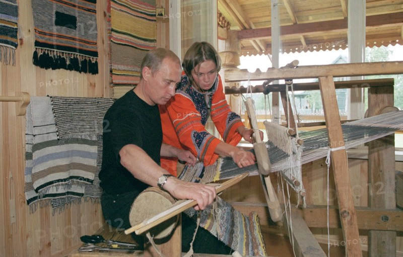 karelia, russia, august 21 2001, president vladimir putin tries his hand at weaving at the ancient loom, while visiting the ethnographic village of verkhniye mondrogi on his way to the kizhi island.