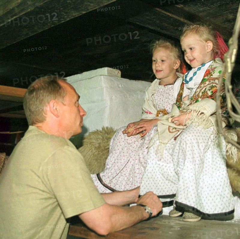 Petrozavodsk, karelia, russia, august 19 2001, president vladimir putin who spends part of his vacation in karelia pictured talking with natasha and vasilisa popovs ,participants of the 'kizhi' folklore ensemble, while visiting on saturday a traditional karelian home, these houses have a specific layout which combines the living quarters and household premises under one roof,    19,08,2001.