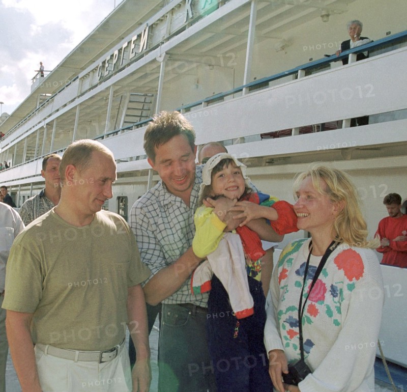 Petrozavodsk, karelia, russia, august 19 2001, president vladimir putin who spends part of his vacation in karelia visited the famous island of kizhi in the onega lake on saturday, picture shows vladimir putin (l) talking with a family of tourists who came by a motorship to kizhi island famous for its outdoor museum of wooden architecture   19,08,2001.