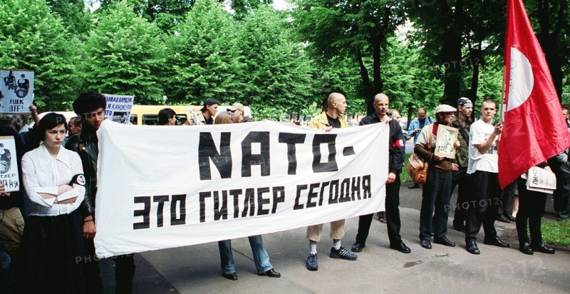Riga, latvia, june 17, 2002: the protestors hold a banner reading 'nato is the hitler of our time', an authorized picket of latvian national bolsheviks protesting against latvia's joining nato, was held at the building of the latvian government, the protestors demanded a referendum on joining nato to be held in latvia.